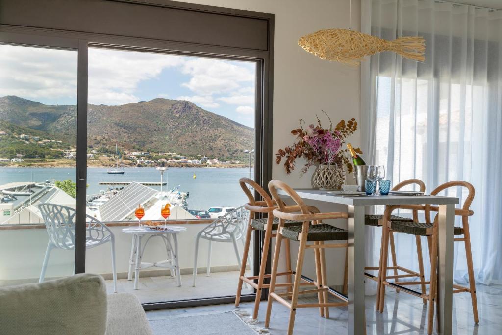 a dining room with a table and chairs and a balcony at Playa Vista Mar in Port de la Selva