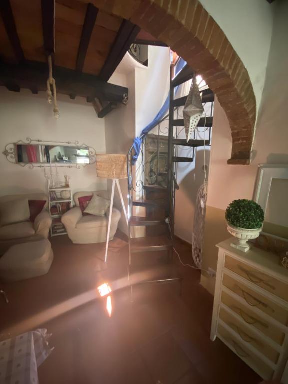 a living room with a spiral staircase in a house at La casetta del frontone in Cetona