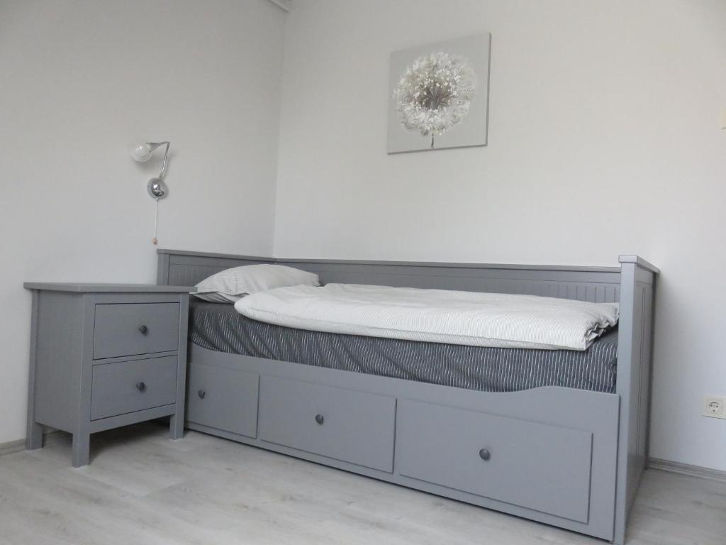 a bed with a bed frame and a nightstand at City Corner Central in Mosonmagyaróvár