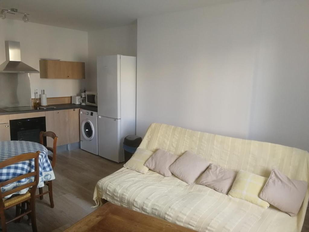 a living room with a couch and a kitchen at Appartement sympa T2 in Alès