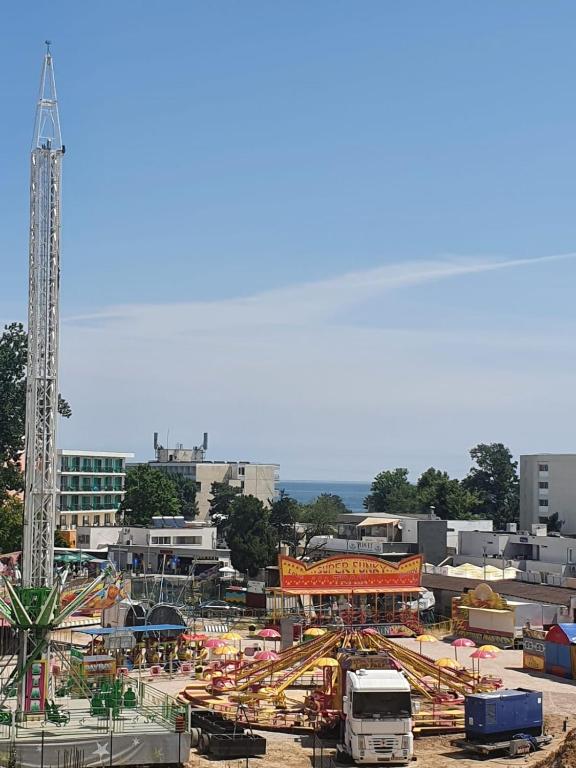 an amusement park with a roller coaster and a carnival at Apartament Alfa Saturn in Saturn