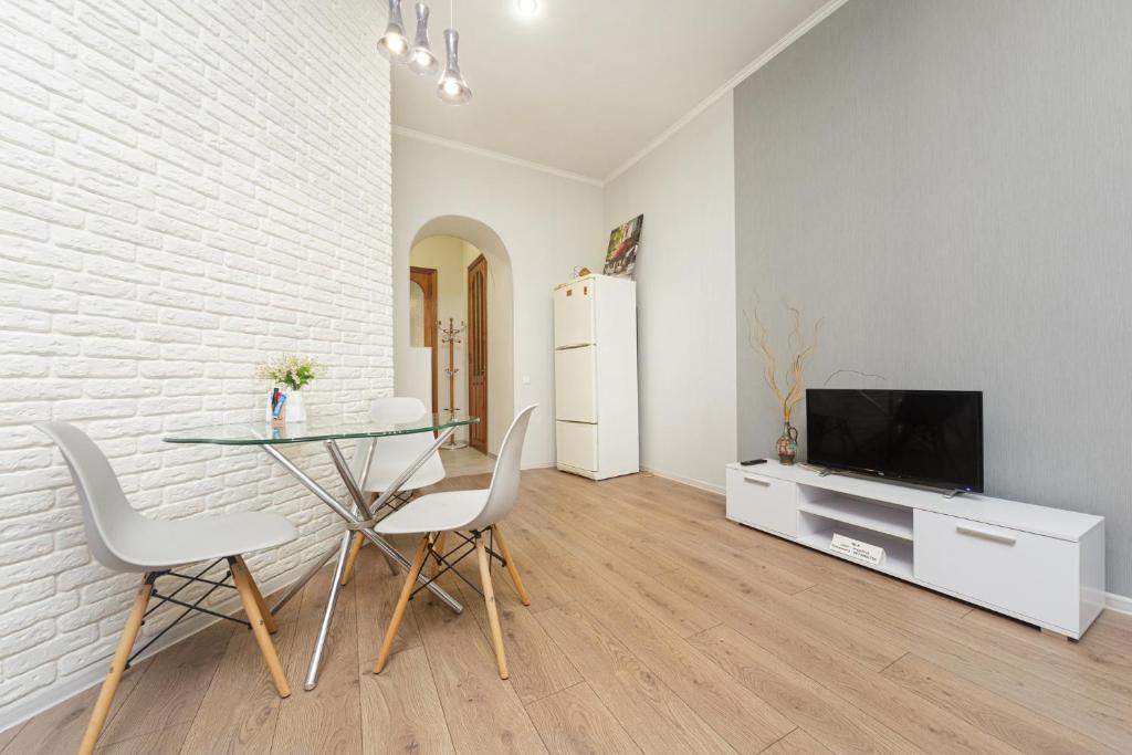 comedor con mesa de cristal y TV en Apartment Zhukovskogo 17, en Odessa