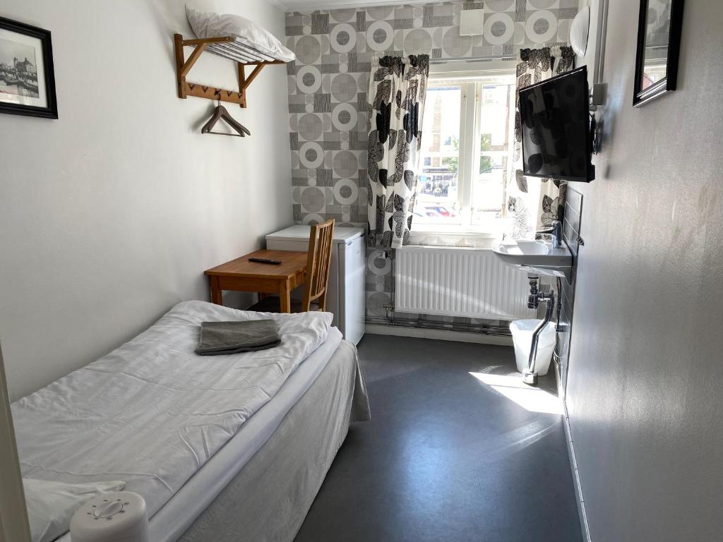 ein kleines Schlafzimmer mit einem Bett und einem Fenster in der Unterkunft Gefle vandrarhem in Gävle