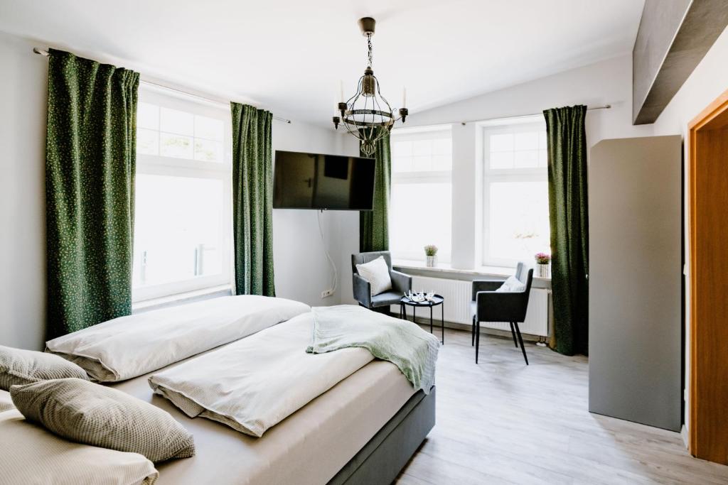1 dormitorio con 2 camas y comedor en Ferienwohnung Waldgasthaus Armeleuteberg en Wernigerode