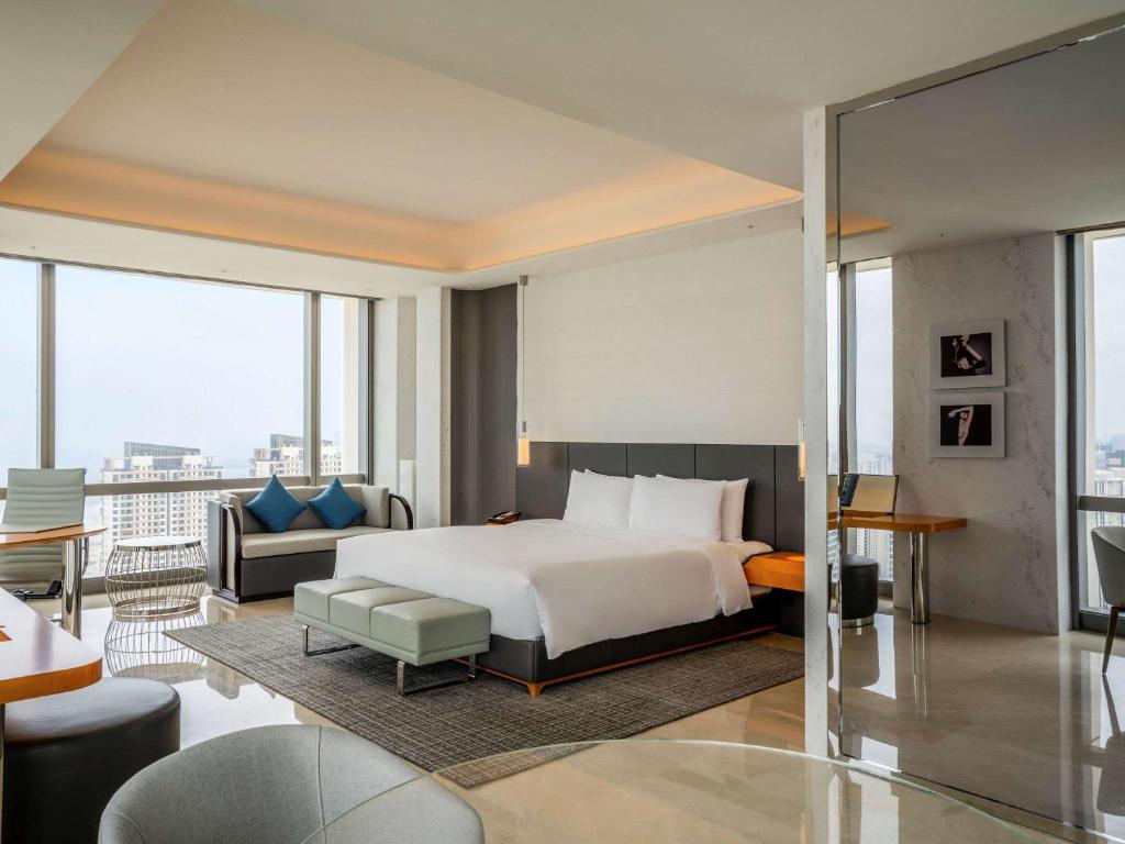 海口市にあるSofitel Haikouのベッドとソファ付きのホテルルーム