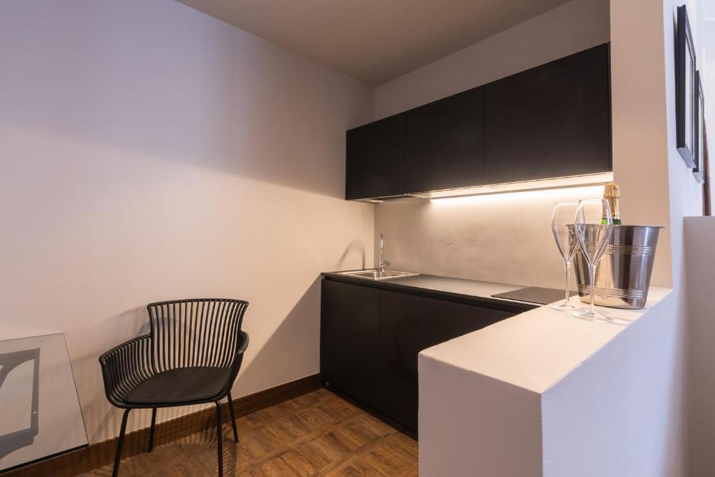 a kitchen with a black and white counter and a chair at Hotel Villa Alberti Portofino Land in Santa Margherita Ligure