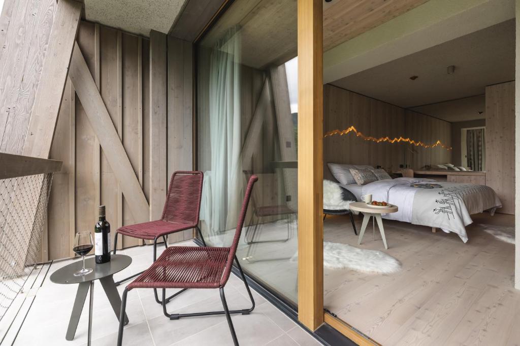 a bedroom with a bed and two chairs and a table at Hotel Bohinj in Bohinj