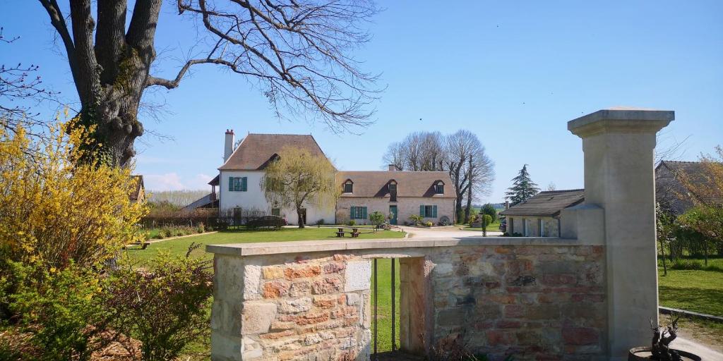 une grande maison avec un mur en pierre devant elle dans l'établissement L'ETAP'CORTELINE, à Saint-Rémy