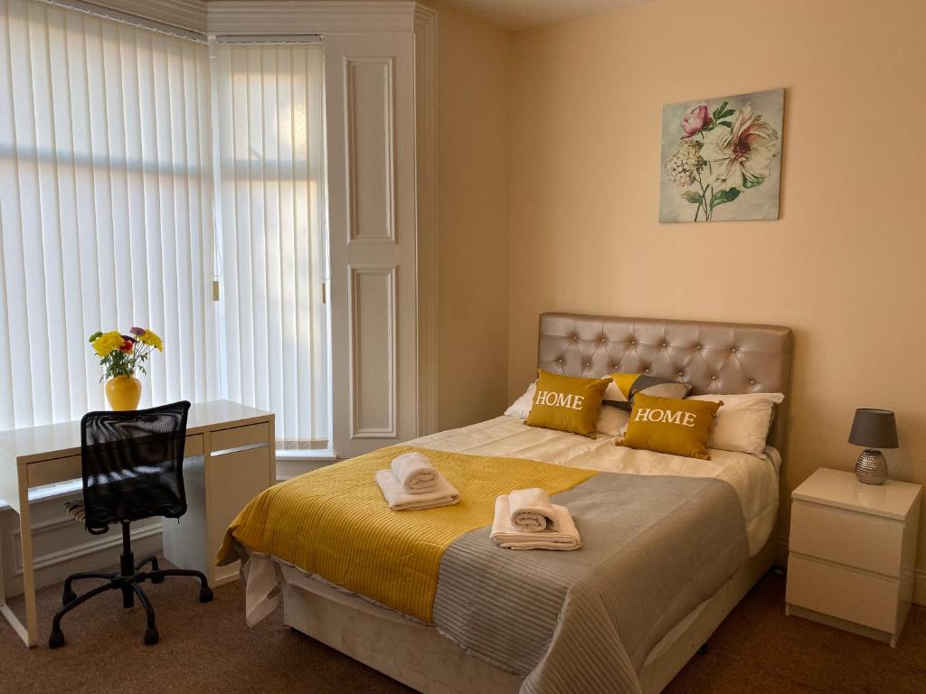 a bedroom with a bed with a desk and a chair at City Centre Ensuite Home - Free parking, near Uni & Hospital in Sunderland