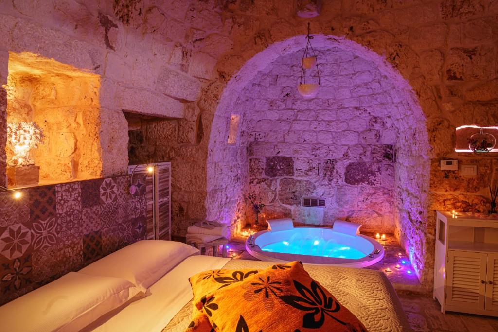 a large room with a tub in a stone wall at Relais Il Trullo della Rupe in Ostuni