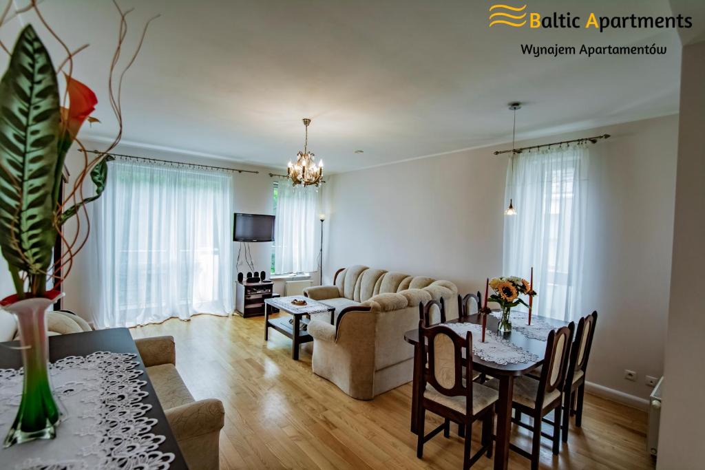 ein Wohnzimmer mit einem Sofa und einem Tisch in der Unterkunft Baltic Apartments - Bałtycka in Świnoujście