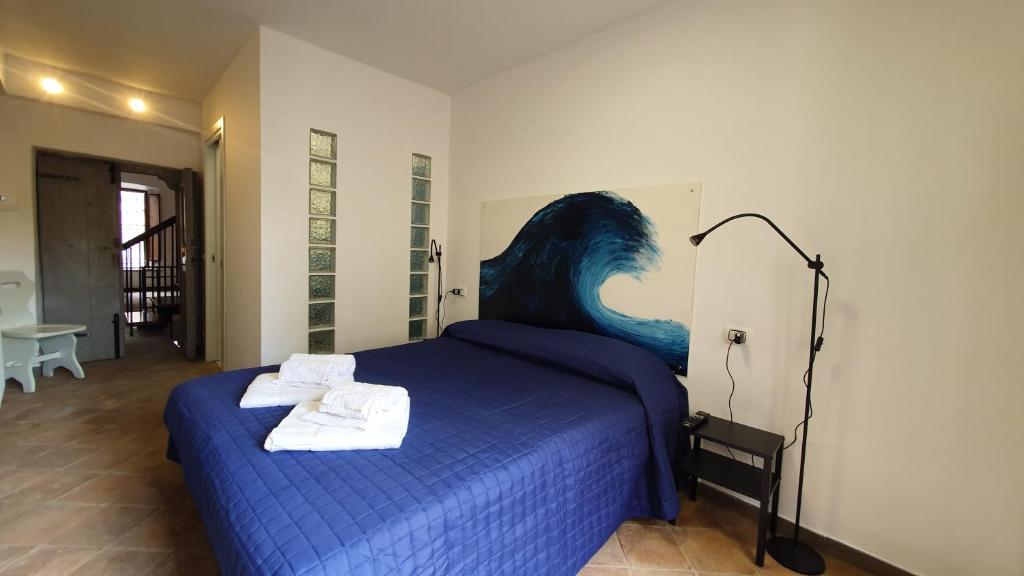 ein Schlafzimmer mit einem blauen Bett und Handtüchern darauf in der Unterkunft Palazzetto la Fonte in Viterbo