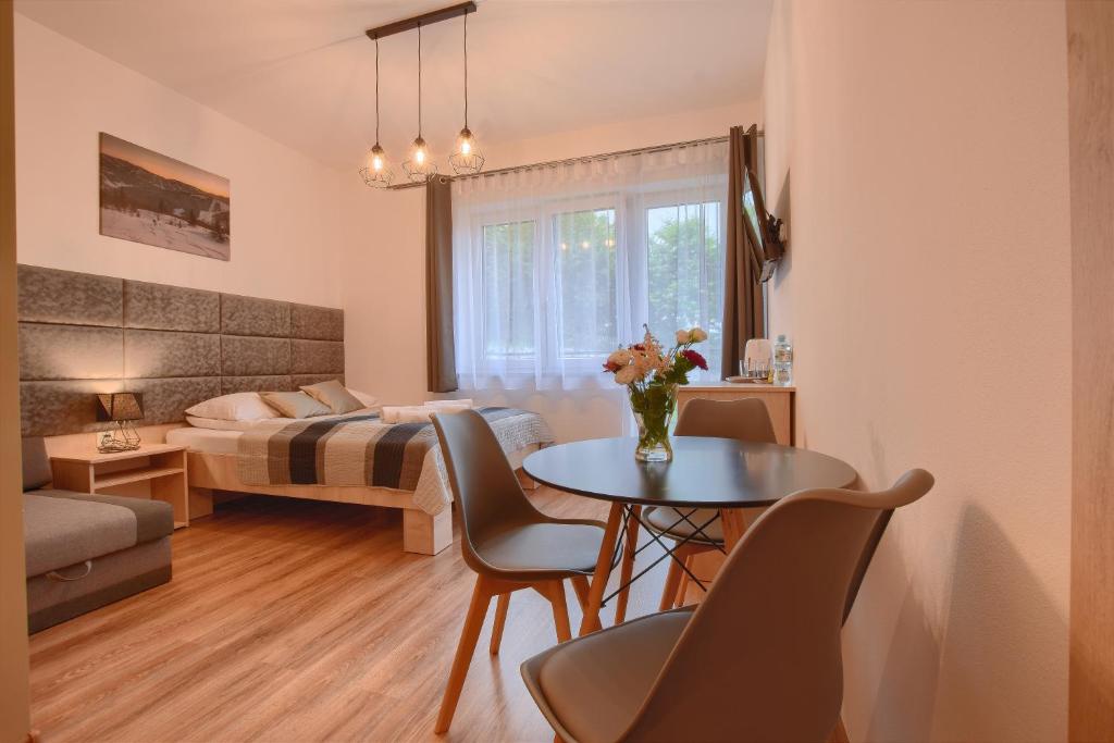 sala de estar con cama, mesa y sillas en Willa Edem, en Wisła