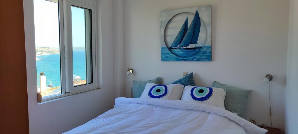 een slaapkamer met een bed met blauwe en witte kussens bij Kalyves Mili's house sea view in Plaka