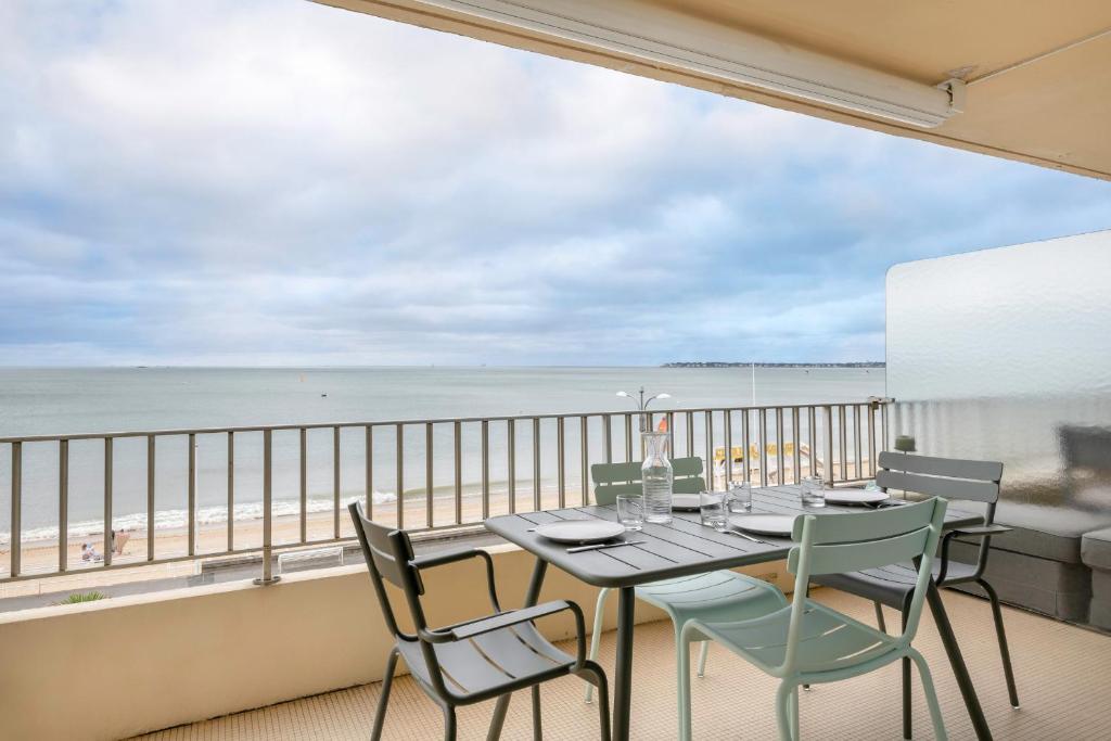 d'une table et de chaises sur un balcon avec vue sur la plage. dans l'établissement Avec vue mer bel appartement au coeur de La Baule, à La Baule