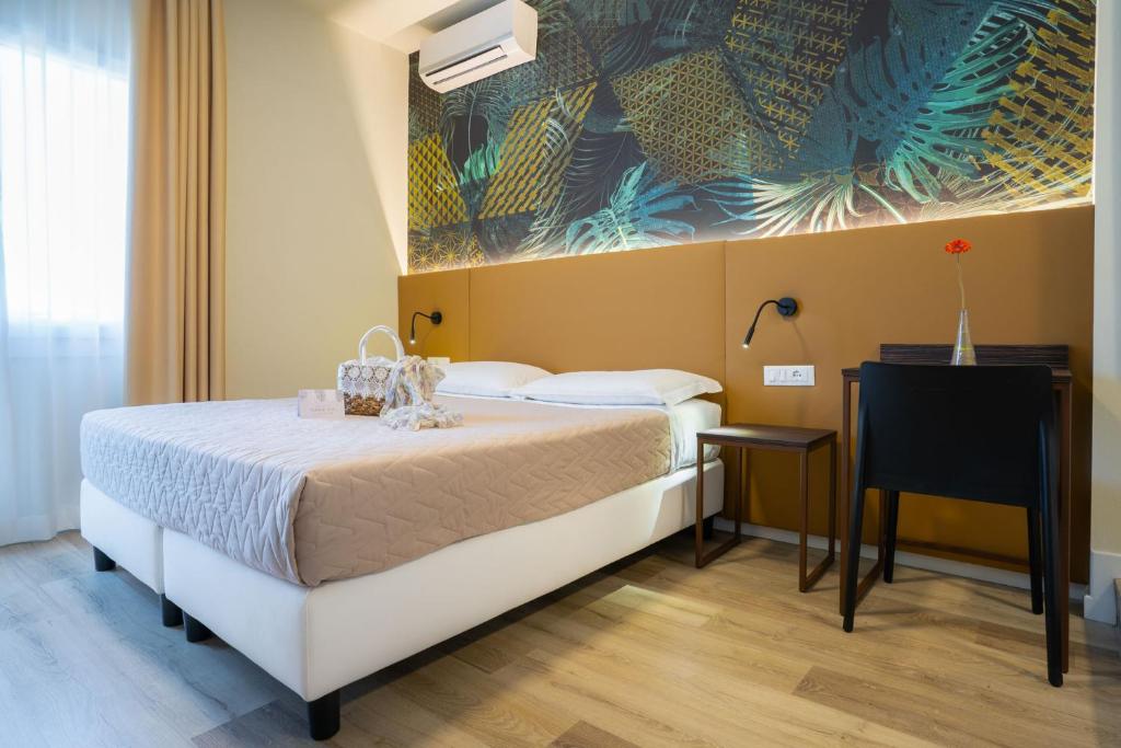 una camera con letto, scrivania e quadro di Hotel Suez a Lido di Jesolo