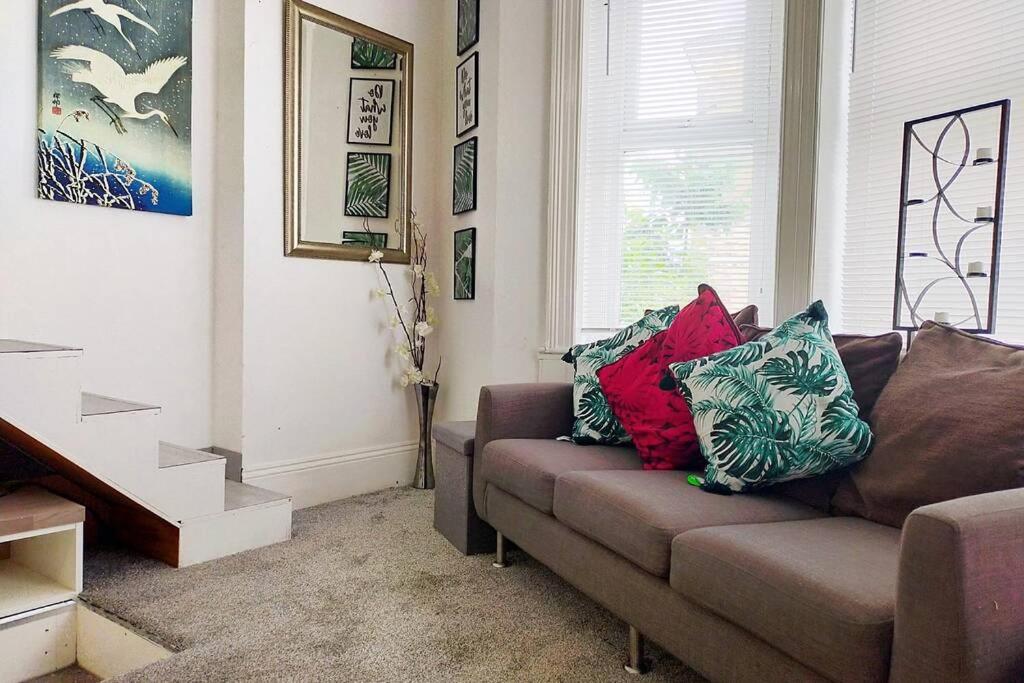 sala de estar con sofá y almohadas en Cute & Cosy Loft-Style Studio close to Beach, en Bournemouth