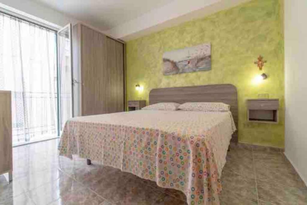 a bedroom with a bed and a yellow wall at Via San Giacomo Primo piano in Ustica