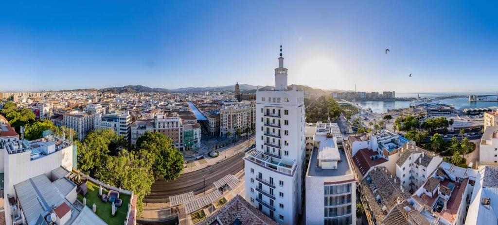 an aerial view of a city with a tall building at Soho Boutique Equitativa in Málaga