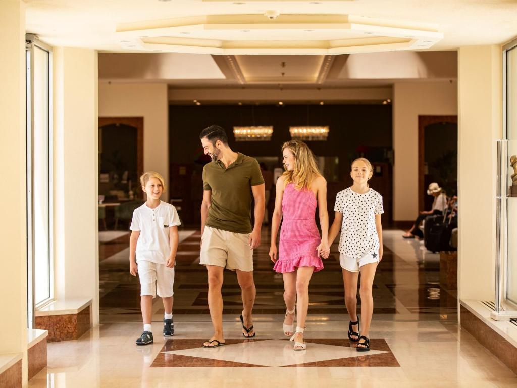 a family walking down a hallway at St Raphael Resort in Limassol