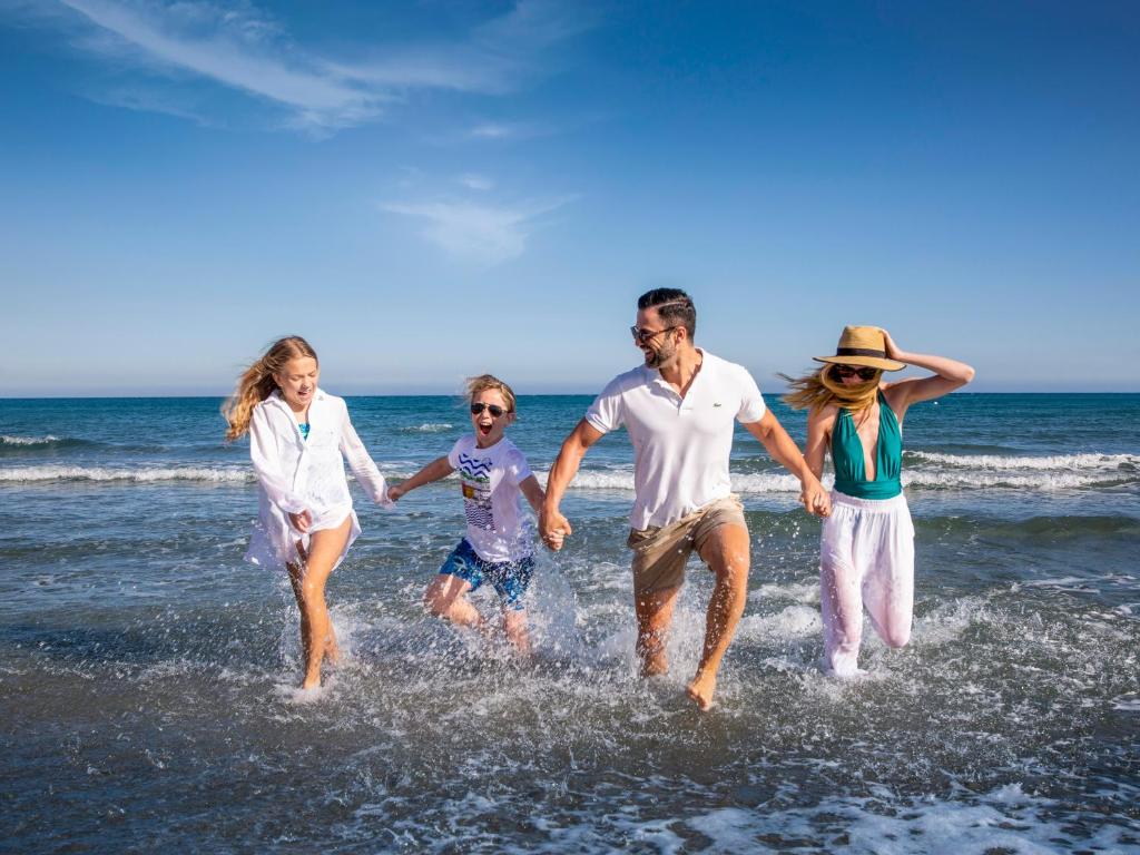 a group of people running on the beach at St Raphael Resort in Limassol