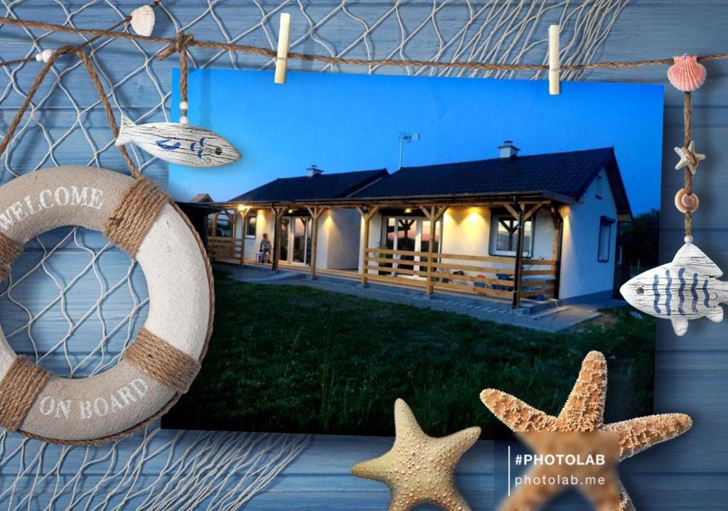 uma casa com estrela-do-mar e um sinal que lê em casa na praia em Osada Familia Śmiechów em Gąski