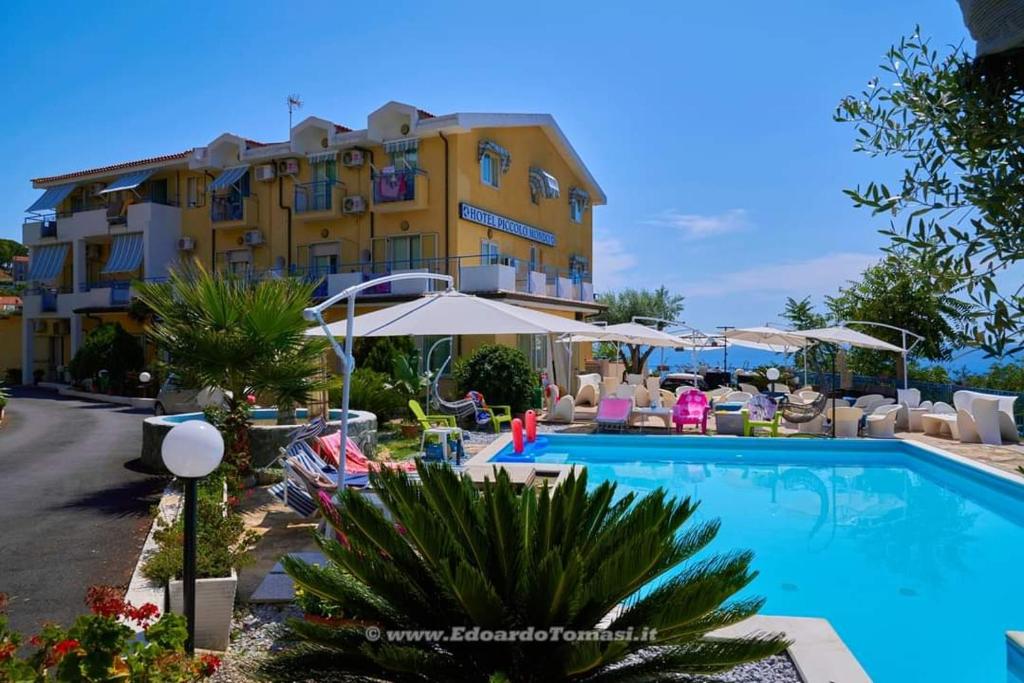 a hotel with a swimming pool in front of a building at Hotel Piccolo Mondo in Acquappesa