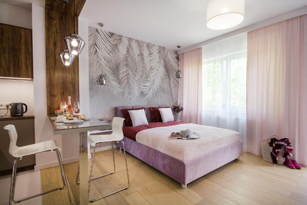 a bedroom with a bed and a table and a desk at W&K Apartments - Glam Suite in Koszalin