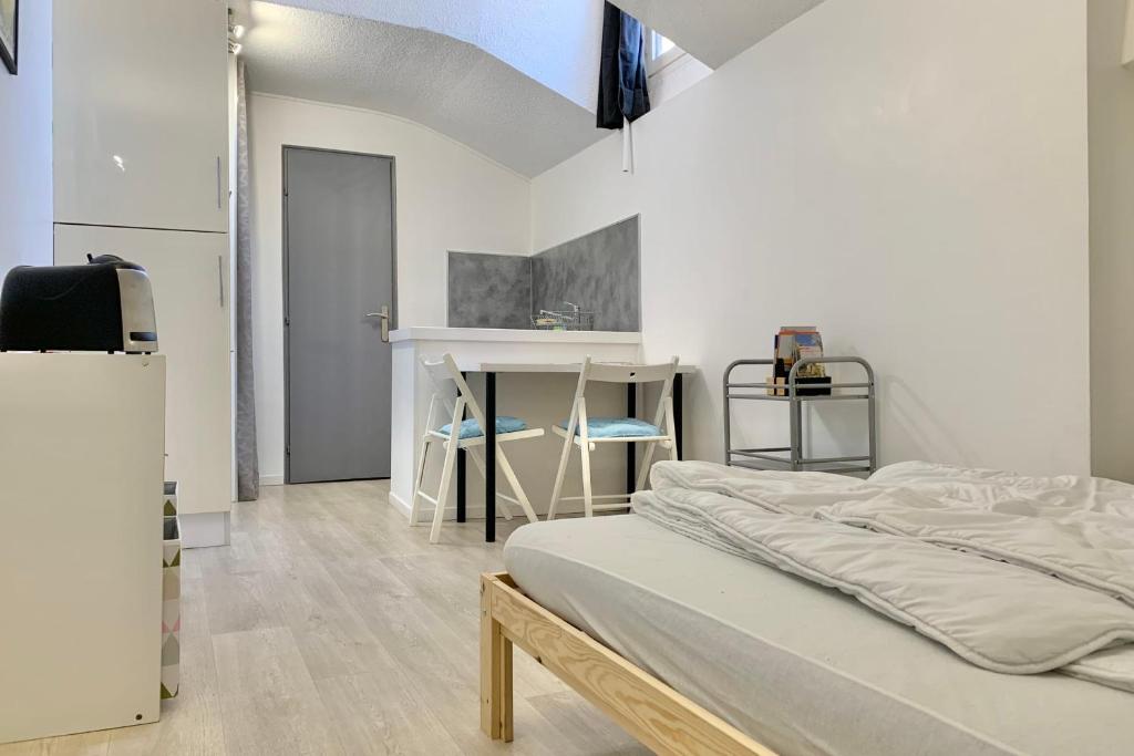 een witte kamer met een bed en een bureau bij Heart of Grenoble #BZ in Grenoble