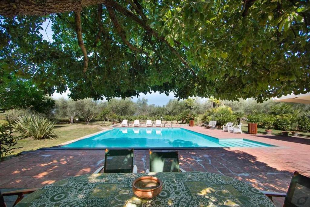 uma piscina com mesa e cadeiras em Villa privata con piscina firenze chianti em Bagno a Ripoli