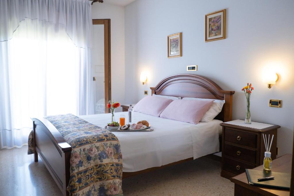 a bedroom with a bed with a tray of food on it at Hotel Da Gigi in Santo Stino di Livenza