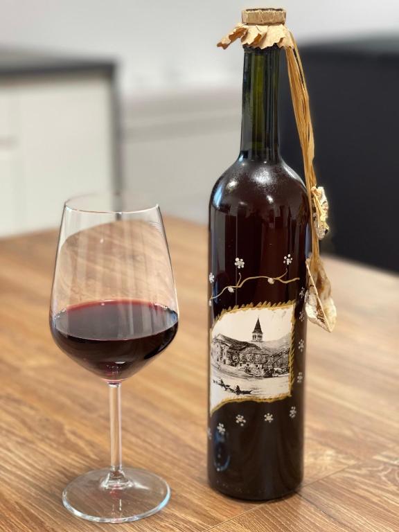 a bottle of wine next to a glass of wine at Apartman Mihaljević in Opuzen