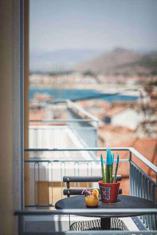a table with a plant on top of a balcony at Porto Bello Nafplio in Nafplio