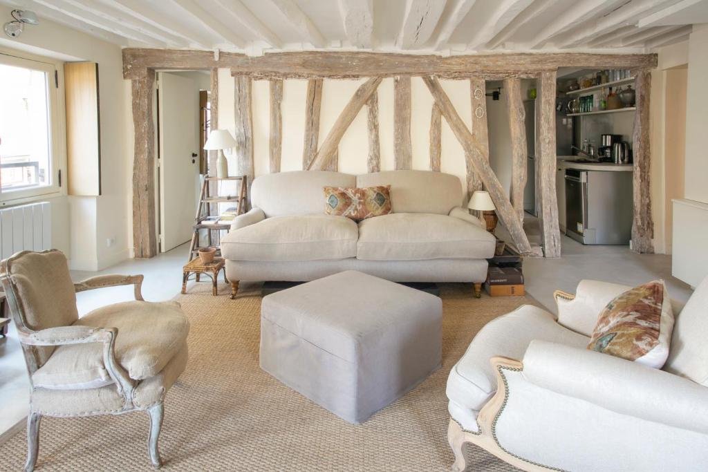 un salon avec un canapé blanc et des chaises dans l'établissement TIMBAUD - CANAL St MARTIN, à Paris