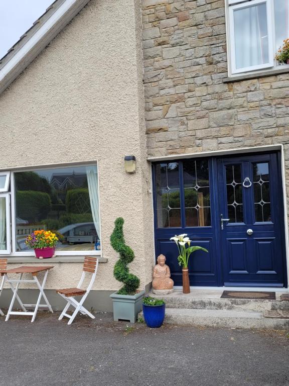 a house with a blue door and a table and chairs at Salmon island view in Dromineer