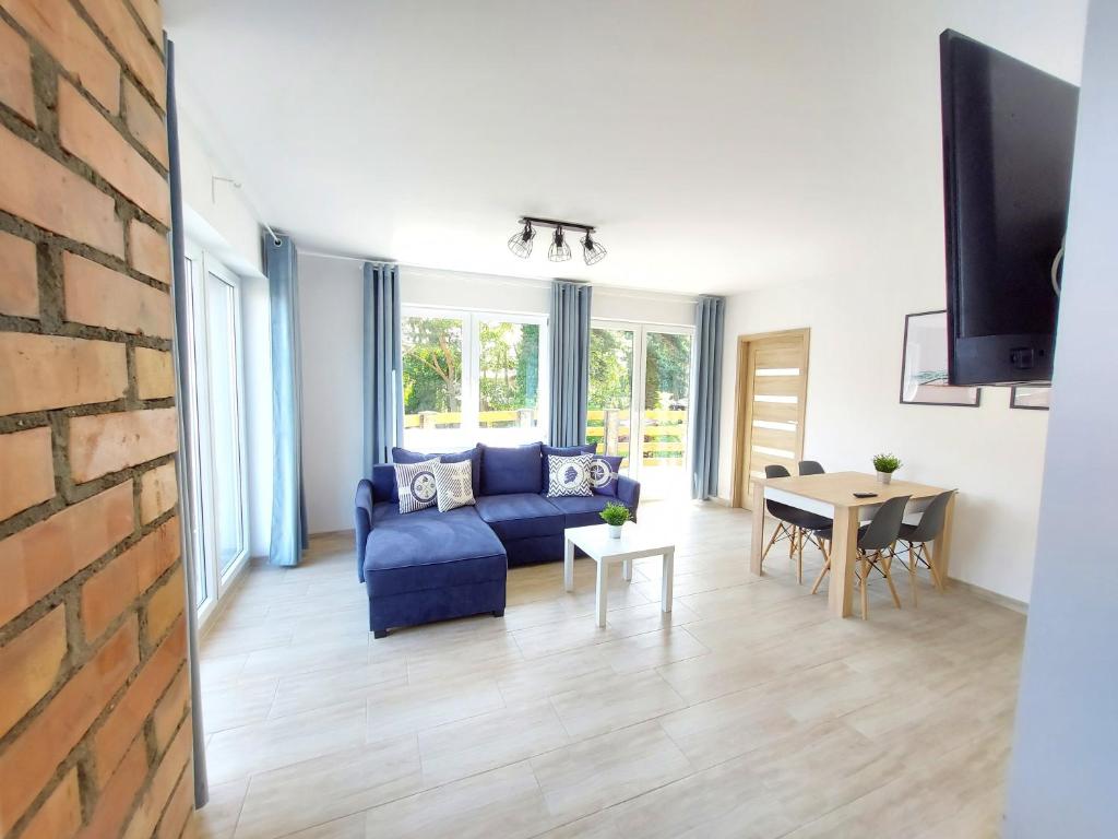 uma sala de estar com um sofá azul e uma mesa em Apartamenty Baltic16 em Ustka