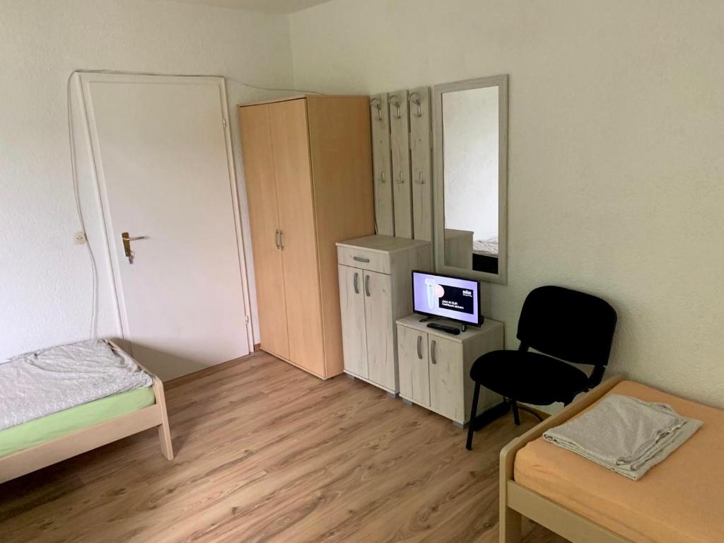 Dieses kleine Zimmer verfügt über ein Schlafzimmer mit einem Schreibtisch und einem Stuhl. in der Unterkunft Neureut in Karlsruhe