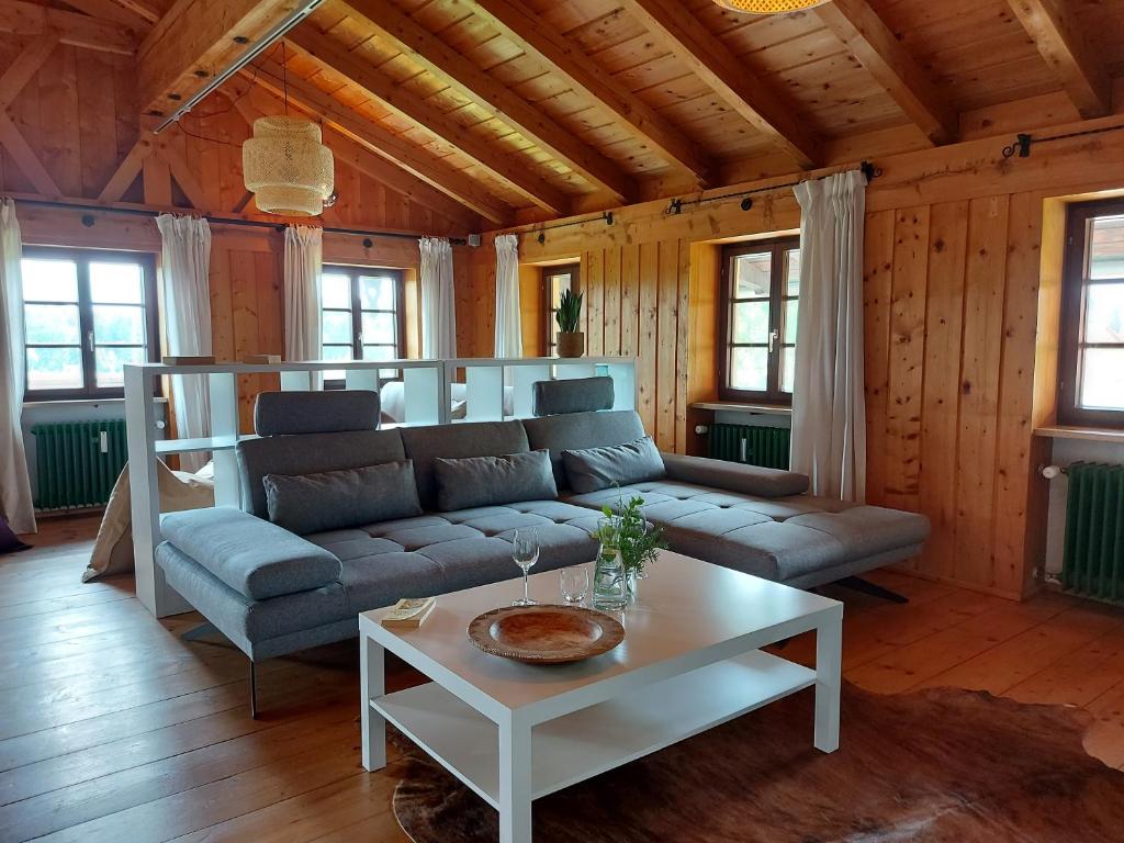 ein Wohnzimmer mit einem Sofa und einem Tisch in der Unterkunft Marxhof Seebruck am Chiemsee in Seeon-Seebruck