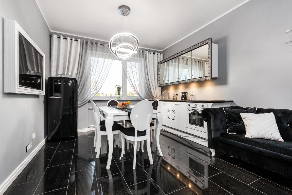 sala de estar con mesa y sofá en Apartamenty Świętojańskie Gdynia, en Gdynia