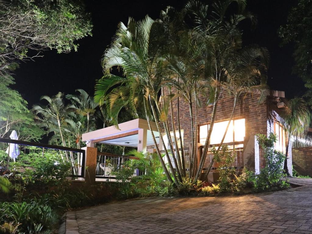 une maison avec des palmiers devant elle la nuit dans l'établissement Pelican's Nest Holiday Home St Lucia, à St Lucia
