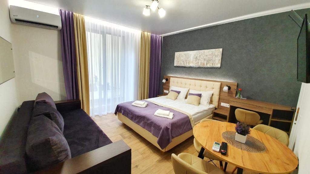 a hotel room with a bed and a table at DeMar Apart Violet in Lviv