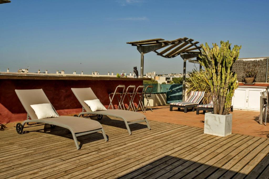 una terraza con sillas y una sombrilla en el techo en Los Condes Penthouse by Hello Homes Sitges en Sitges