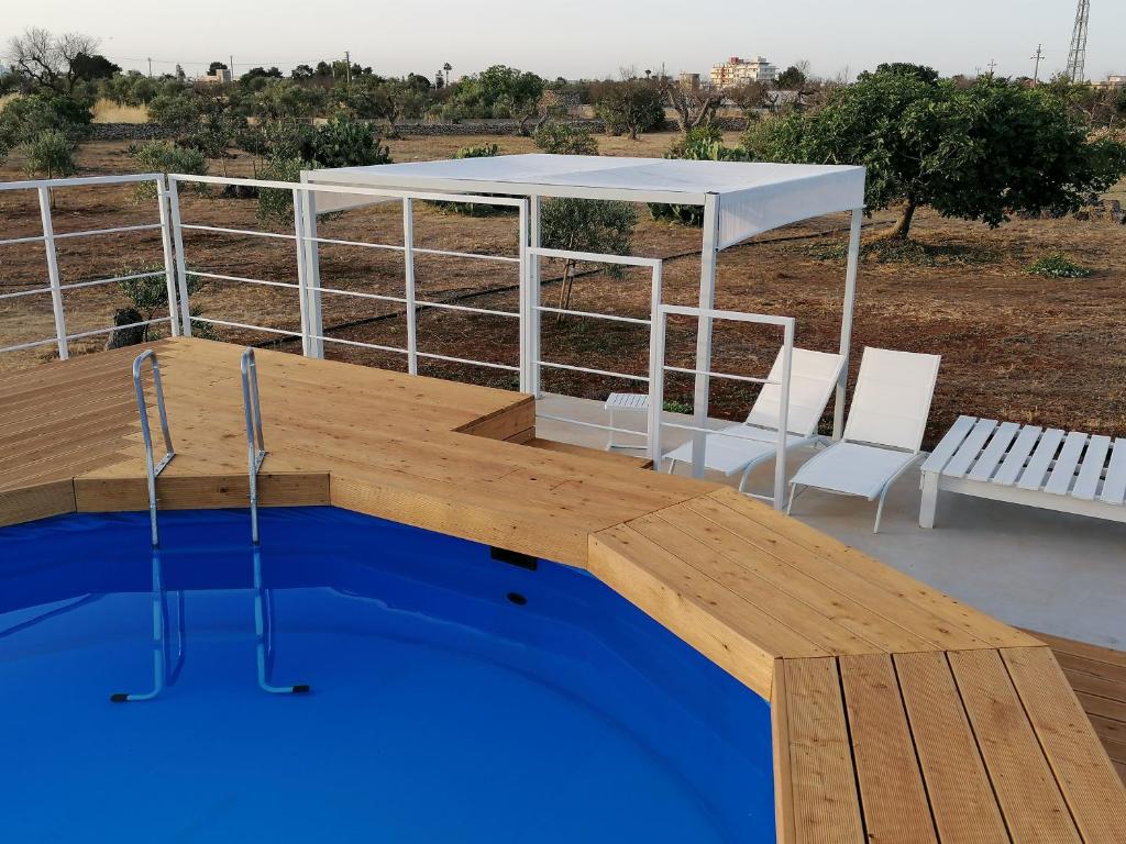 uma piscina com uma mesa e cadeiras num deque em Villa Le Site em Racale