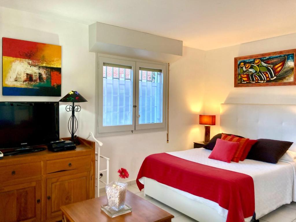 1 dormitorio con 1 cama y TV de pantalla plana en Los Globos Beach Studio by Hello Homes Sitges en Sitges