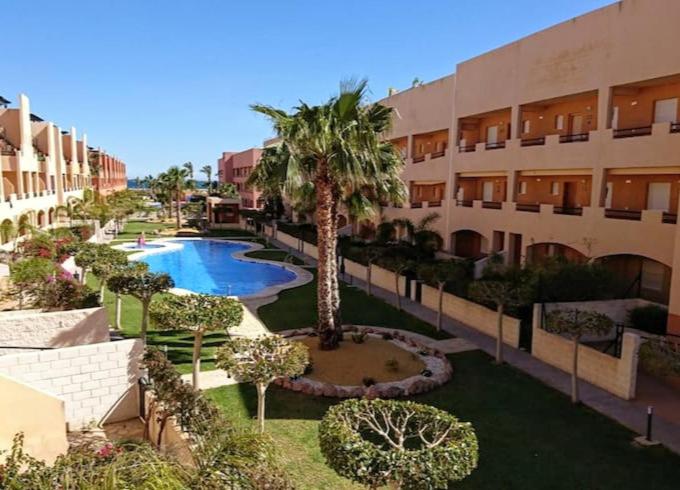 an apartment complex with a pool and a palm tree at Paradise Nassau Vera Beach in Vera