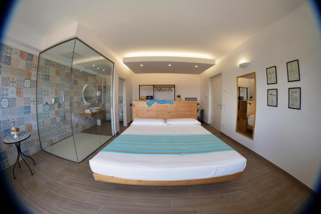 a bedroom with a large bed and a shower at Dimora EFFE - Eco B&B in Termoli