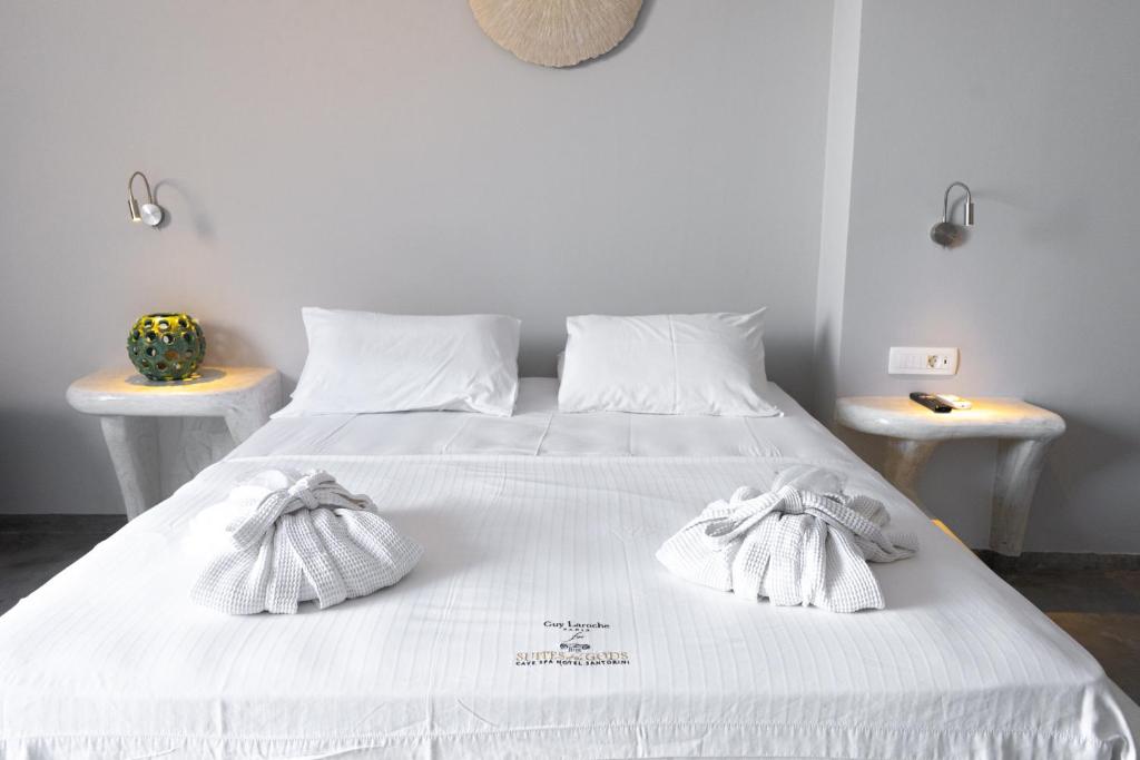 białe łóżko z białą pościelą i ręcznikami w obiekcie Demilmar Luxury Suites w mieście Perissa