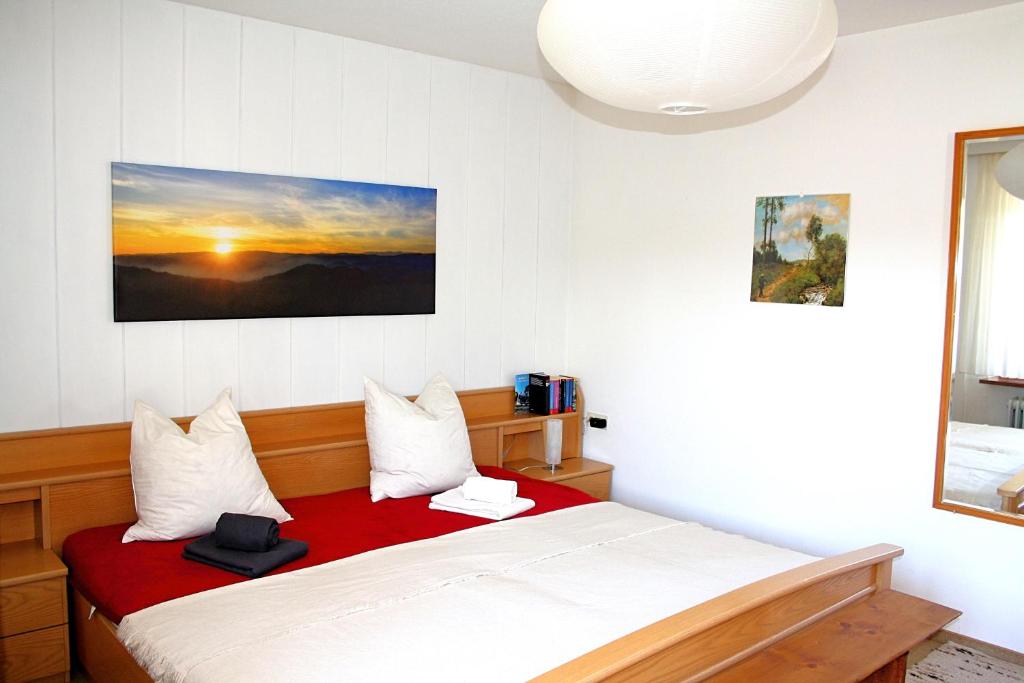 a bedroom with a bed with a red blanket at Gemütliche Fewo mit Sonnenterrasse in Bernau im Schwarzwald