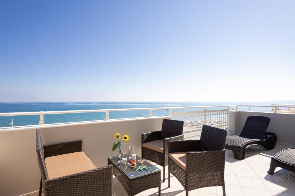 balcone con sedie, tavoli e vista sull'oceano di SEPERI sea & sun a Rethymno