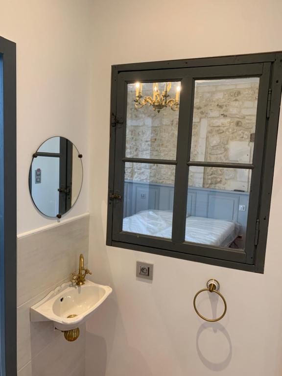 a bathroom with a sink and a mirror at CHAMBRE BALCON in Pons